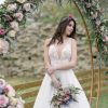 Νυφικό Gina σε Α γραμμή με δαντέλα κάτω από ανθισμένη αψίδα - Fashion Brides Σέρρες.