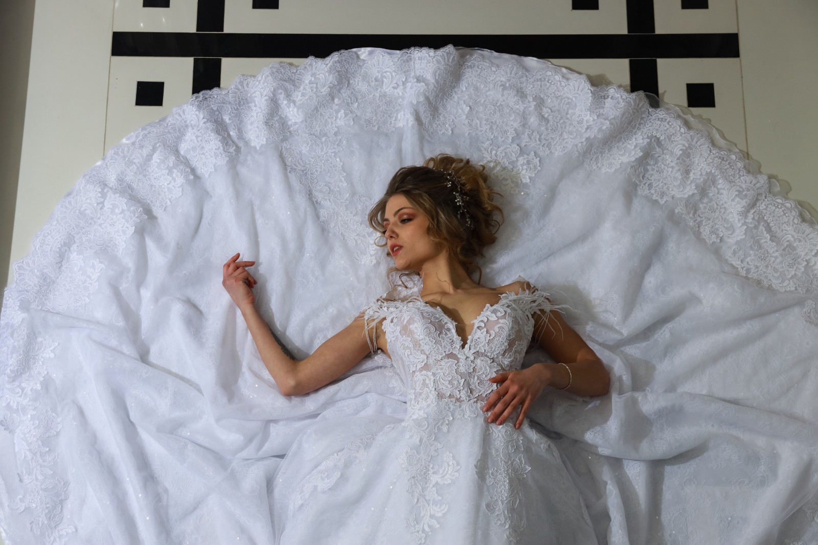 Νυφικό Gianna με δαντέλα σε ξαπλωτή πόζα - Fashion Brides Σέρρες.